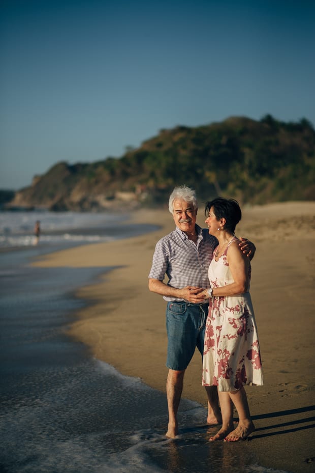 Pareja de abuelos abrazados en la orilla del mar